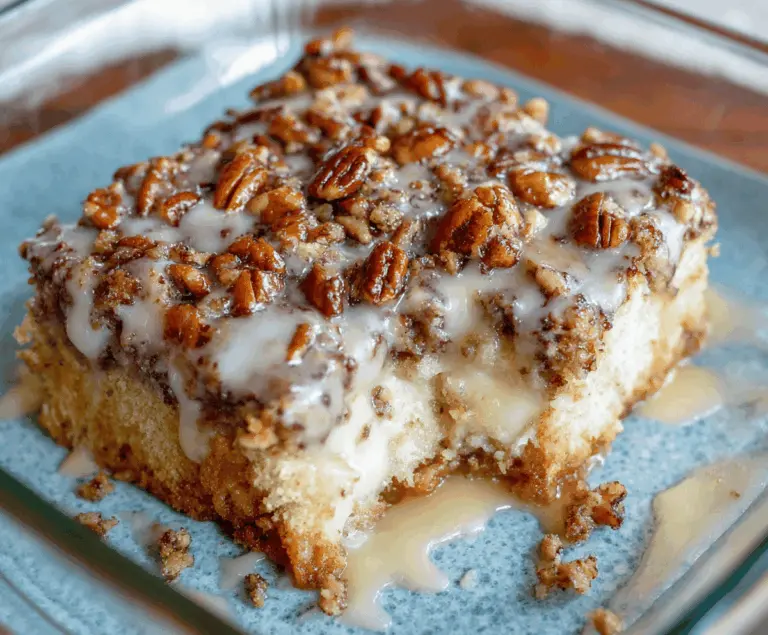 Delicious Butter Pecan Praline Poke Cake topped with caramelized pecans and creamy frosting, perfect for dessert lovers.