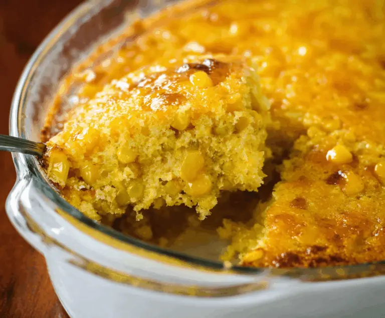 Creamy golden Corn Pudding served in a rustic dish, topped with fresh herbs, perfect as a comforting side dish for family dinners.