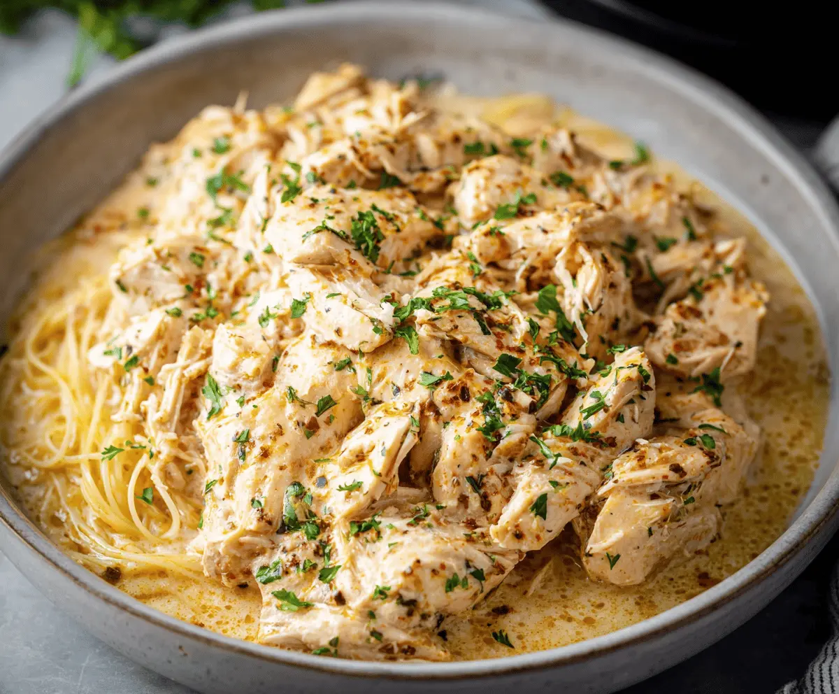 Creamy Crockpot Angel Chicken served with rice, featuring tender chicken breasts in a flavorful sauce.