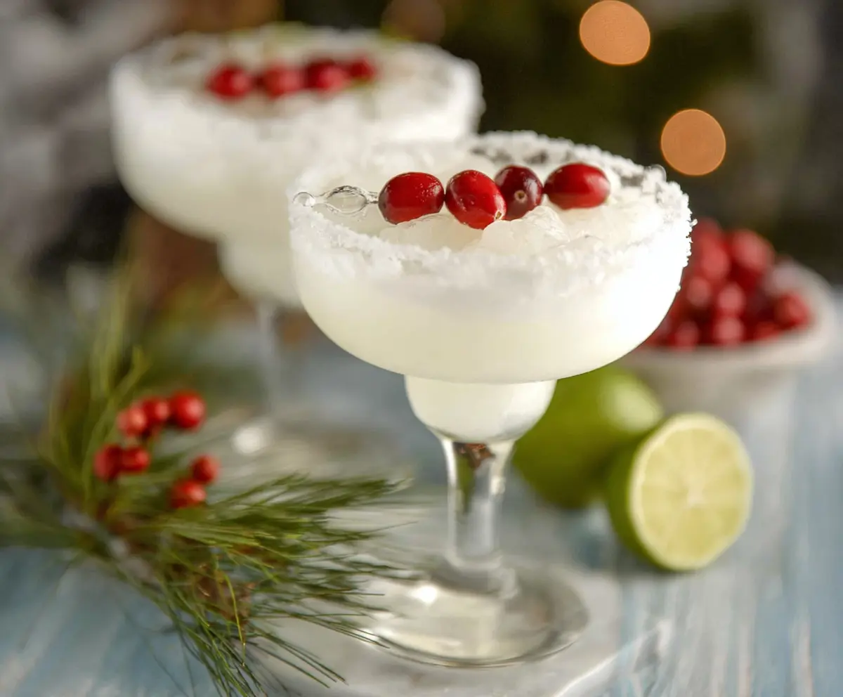 Refreshing White Christmas Margarita in a elegant glass garnished with a lime wedge.