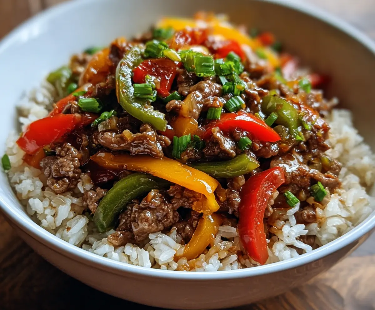 Delicious beef and pepper rice bowl with colorful vegetables and savory sauce.