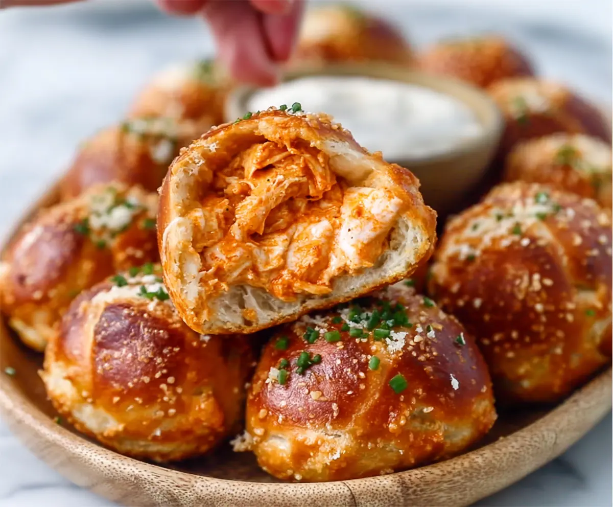 Buffalo Chicken Stuffed Pretzel Bites on a plate, crispy and golden with a spicy buffalo sauce drizzle.