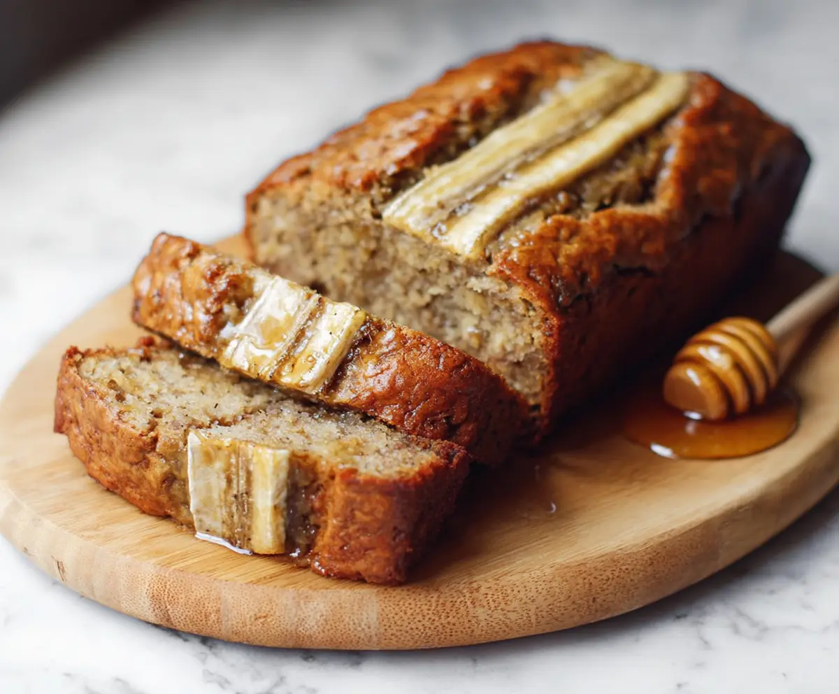 Delicious honey vanilla banana bread sliced and ready to serve on a wooden table.